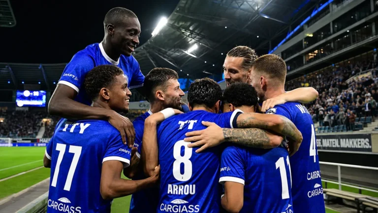 Een groep KAA Gent-spelers viert samen onder de stadionlichten.