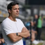 David Hubert staat geconcentreerd langs de zijlijn in een voetbalstadion.