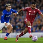 Twee spelers in rood en blauw vechten om de bal tijdens een wedstrijd.
