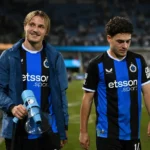 Twee Club Brugge-spelers wandelen na een wedstrijd langs de zijlijn.