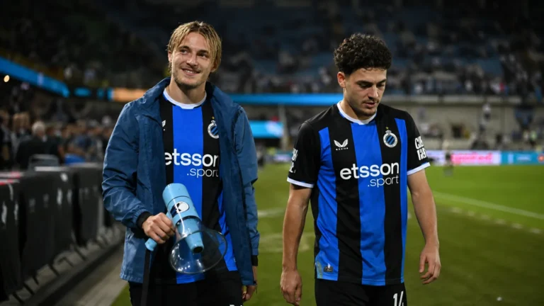 Twee Club Brugge-spelers wandelen na een wedstrijd langs de zijlijn.