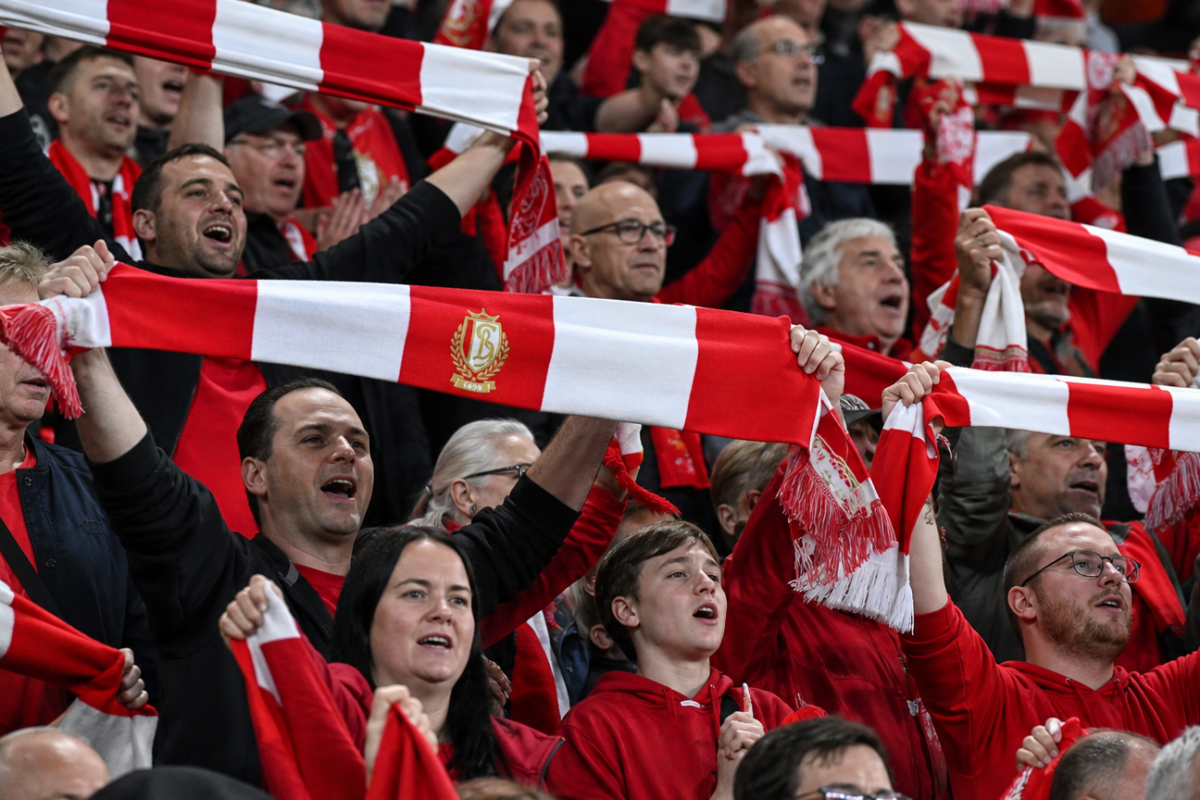 Supporters van Standard vieren de zege in de tribunes met rood-witte sjaals.