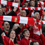 Supporters van Standard vieren de zege in de tribunes met rood-witte sjaals.