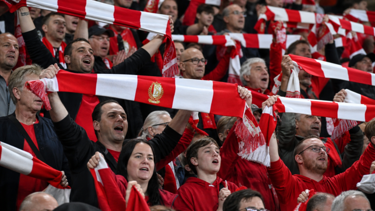 Supporters van Standard vieren de zege in de tribunes met rood-witte sjaals.