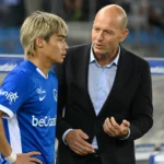 Jess Thorup staat met een Genk-speler langs de zijlijn voor een wedstrijd.