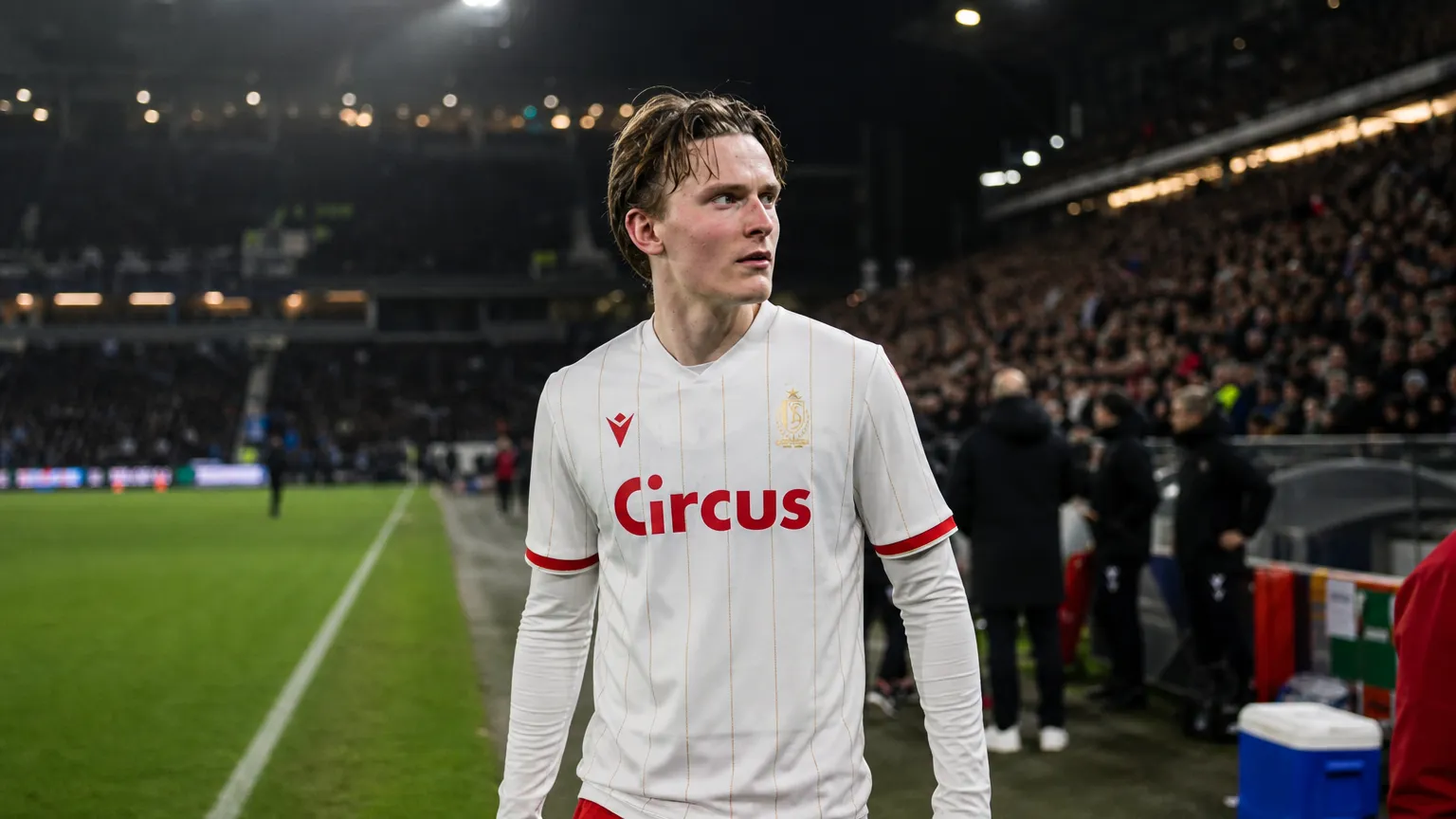 Ibe Hautekiet in het witte shirt van Standard aan de zijlijn van een stadion.