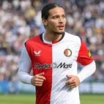 Anis Hadj Moussa in het shirt van Feyenoord op een voetbalveld.