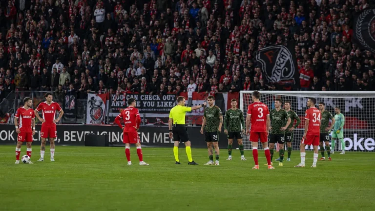 Spelers van FC Utrecht en Go Ahead Eagles staan op het veld tijdens een onderbreking van de wedstrijd.