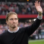 Mika Godts applaudisseert geëmotioneerd langs het veld voor zijn afscheid bij Ajax.