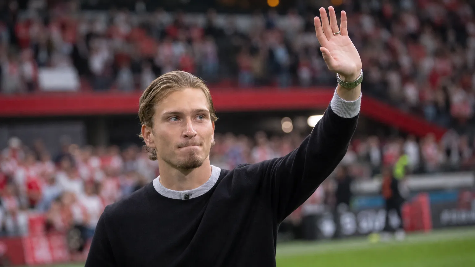 Mika Godts applaudisseert geƫmotioneerd langs het veld voor zijn afscheid bij Ajax.