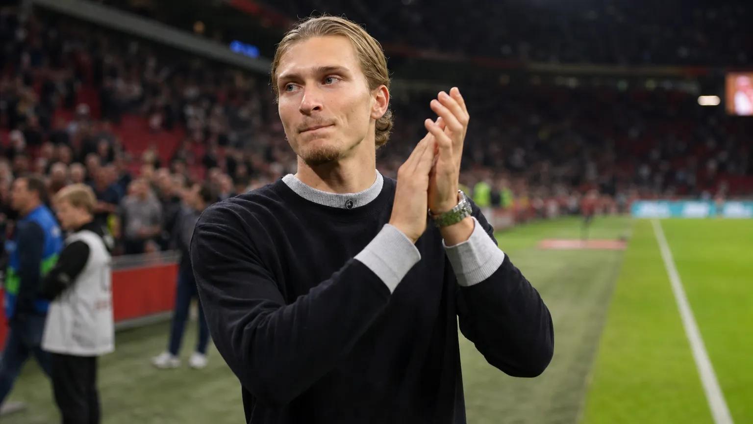 Mika Godts applaudisseert langs het veld in de Johan Cruijff ArenA.