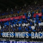 Collectieve Club Brugge-supporters met blauw-zwarte vlaggen op de tribune van Jan Breydel.