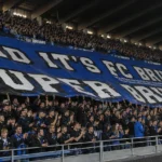 Een volle tribune met blauw-zwarte supporters die juichen in Jan Breydel.