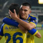 Ilias Sebaoui omhelst een ploegmaat van STVV op een regenachtig veld.