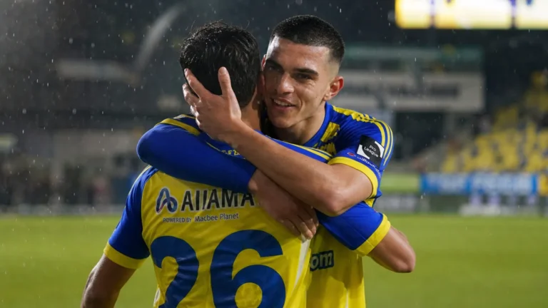 Ilias Sebaoui omhelst een ploegmaat van STVV op een regenachtig veld.