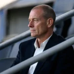Jess Thorup observeert aandachtig een wedstrijd vanuit de tribune.