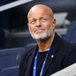 Een niet-spelende clubvertegenwoordiger in donkere kleding op de tribune van een stadion.