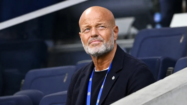 Een niet-spelende clubvertegenwoordiger in donkere kleding op de tribune van een stadion.