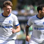 Twee spelers van KAA Gent in witte wedstrijdshirts tijdens een nieuw wedstrijmoment.
