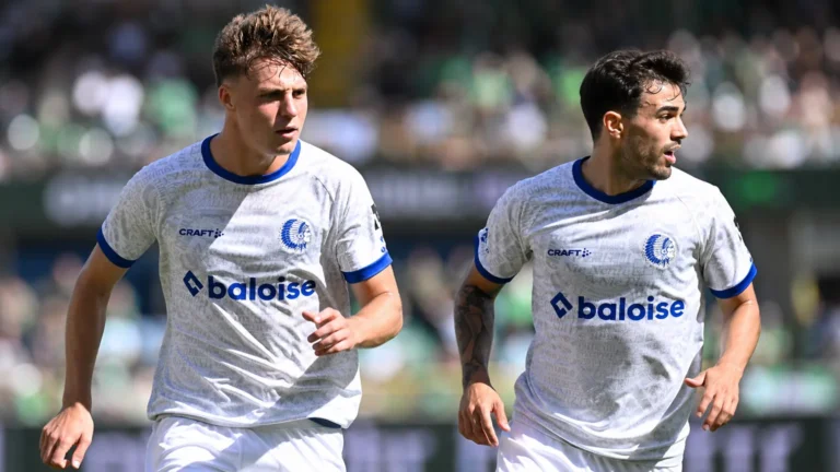 Twee spelers van KAA Gent in witte wedstrijdshirts tijdens een nieuw wedstrijmoment.