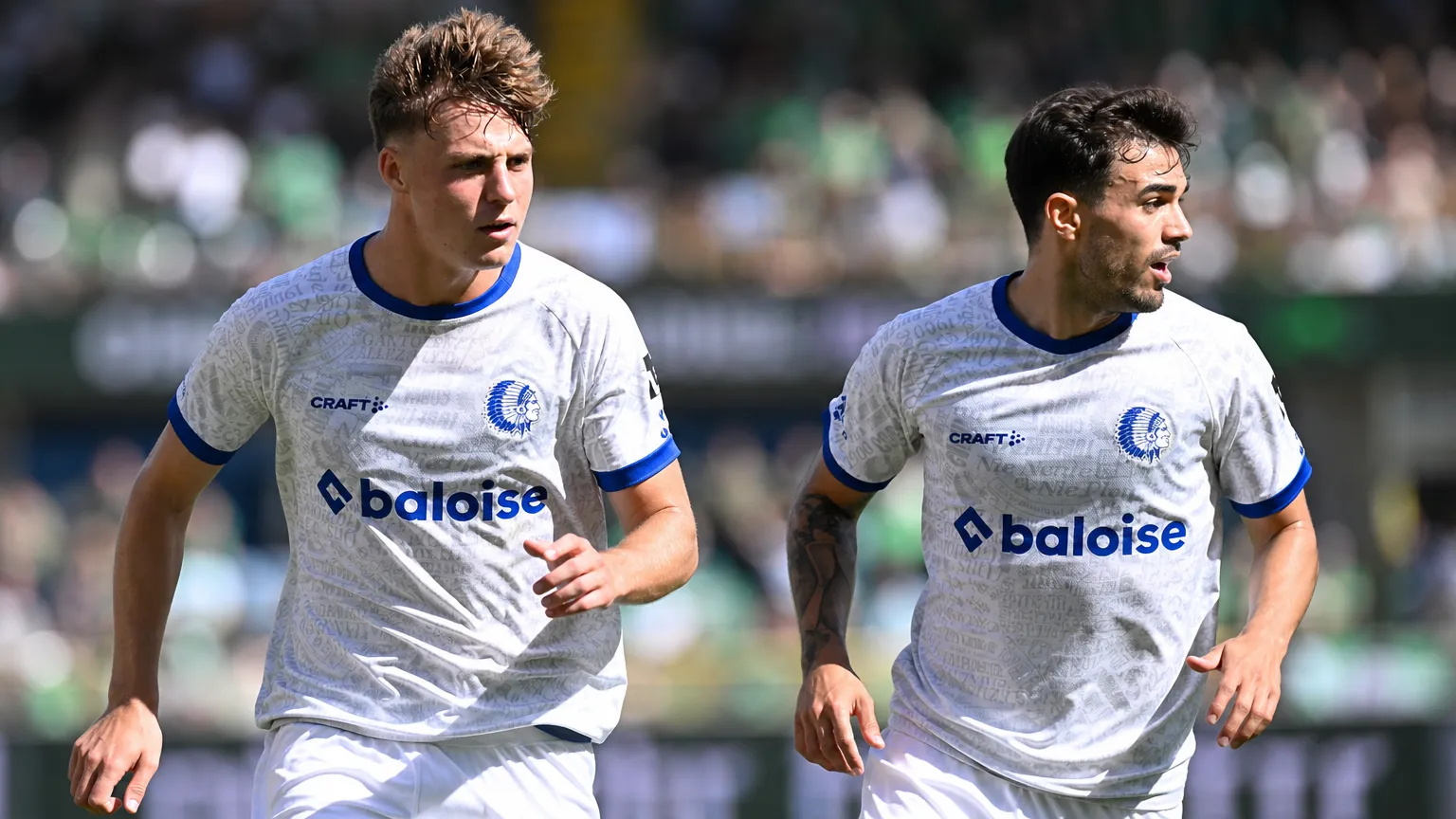 Twee spelers van KAA Gent in witte wedstrijdshirts tijdens een nieuw wedstrijmoment.