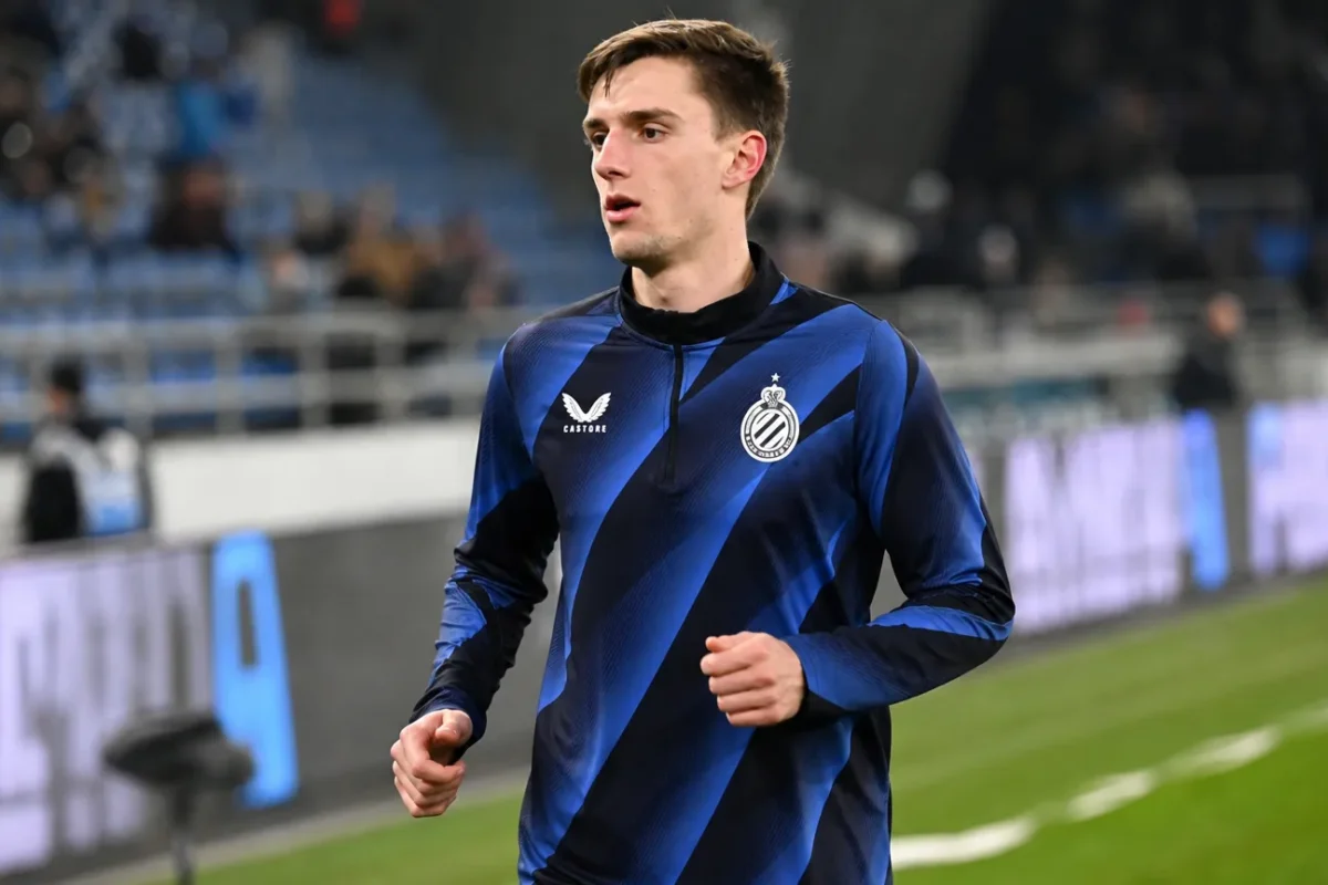 Jorne Spileers warmt op in Club Brugge-kleding langs het veld.