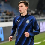 Jorne Spileers warmt op in Club Brugge-kleding langs het veld.