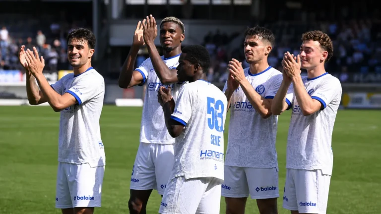 Een groep KAA Gent-spelers viert samen op het veld na de wedstrijd.