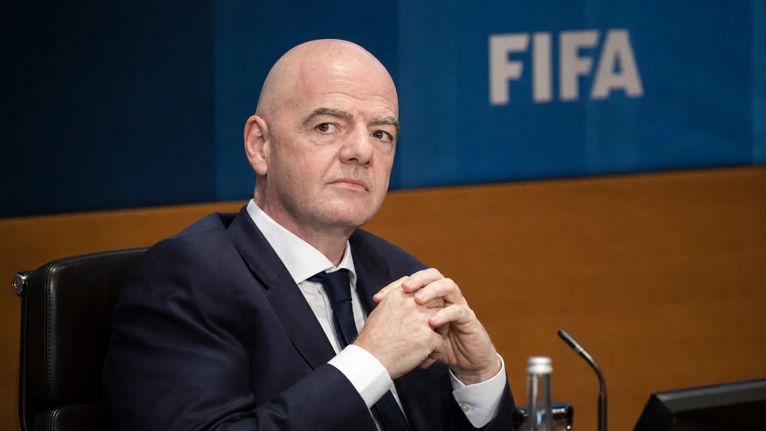 Gianni Infantino in pak in een officiƫle FIFA-conferentieomgeving.