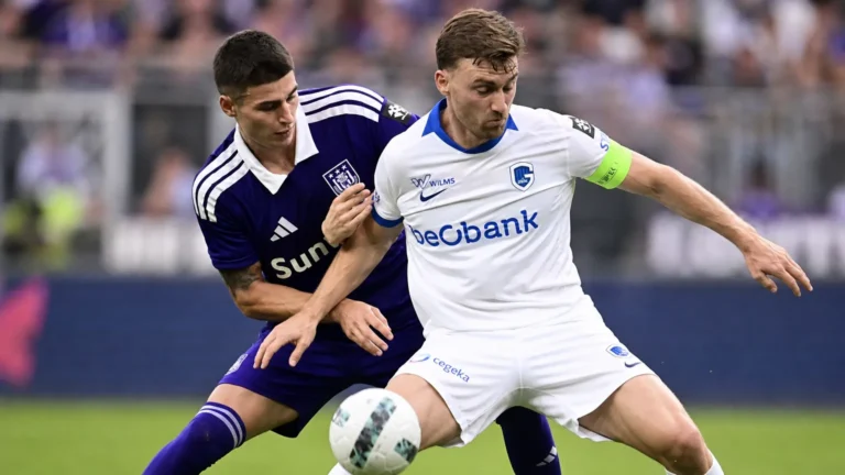 Twee spelers van Anderlecht en KRC Genk vechten om de bal tijdens een wedstrijd.