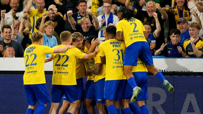 Beveren-spelers vieren samen een doelpunt aan de zijlijn tijdens een wedstrijd.
