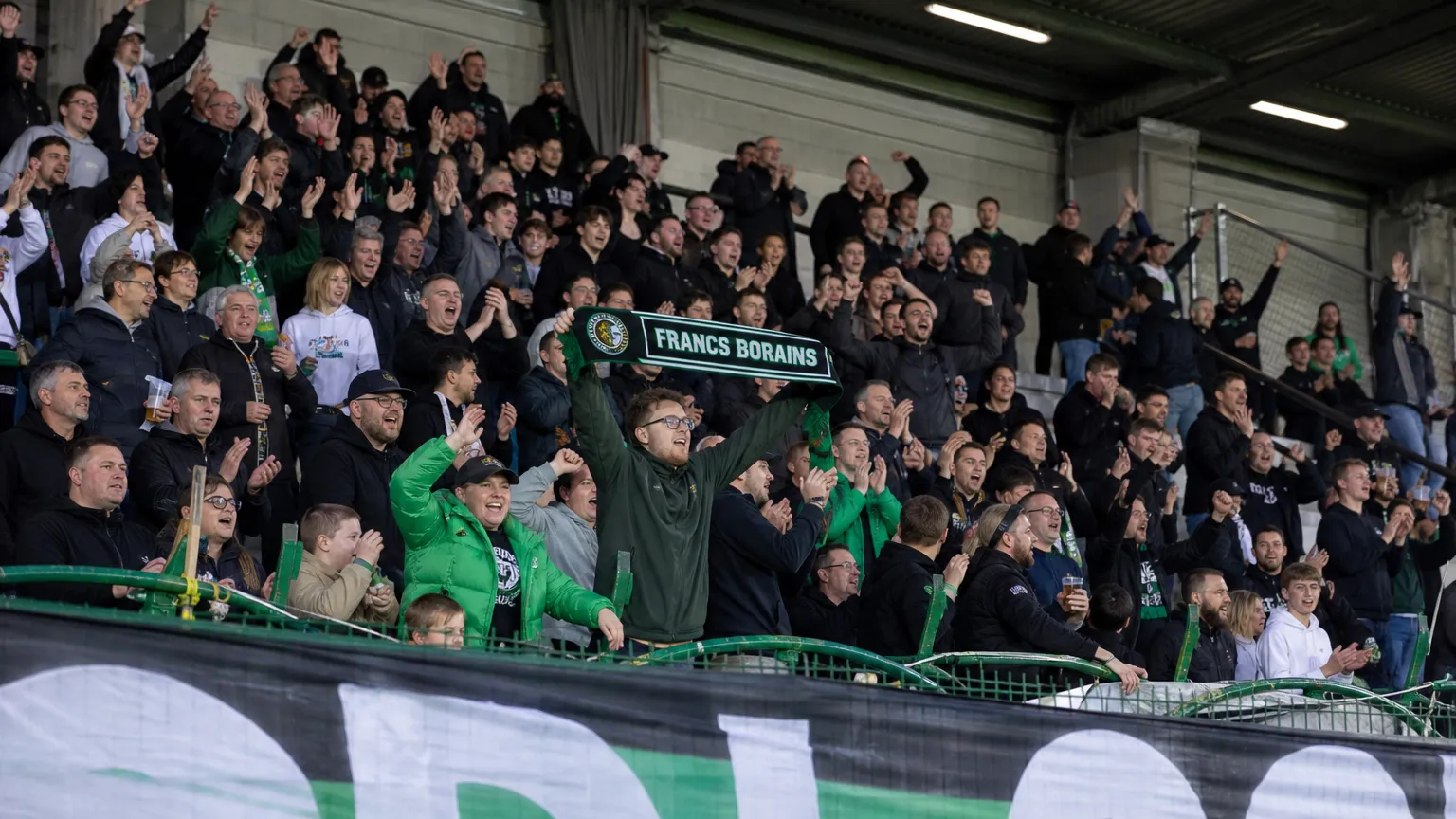 Supporters van Francs Borains vieren op de thuistribune met clubsjaals.