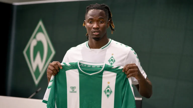 Moussa N’Diaye poseert met een Werder Bremen-shirt tijdens een officiële clubpresentatie.