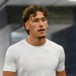 Lucas Stassin in neutrale sportkleding in de mixed zone van een stadion.