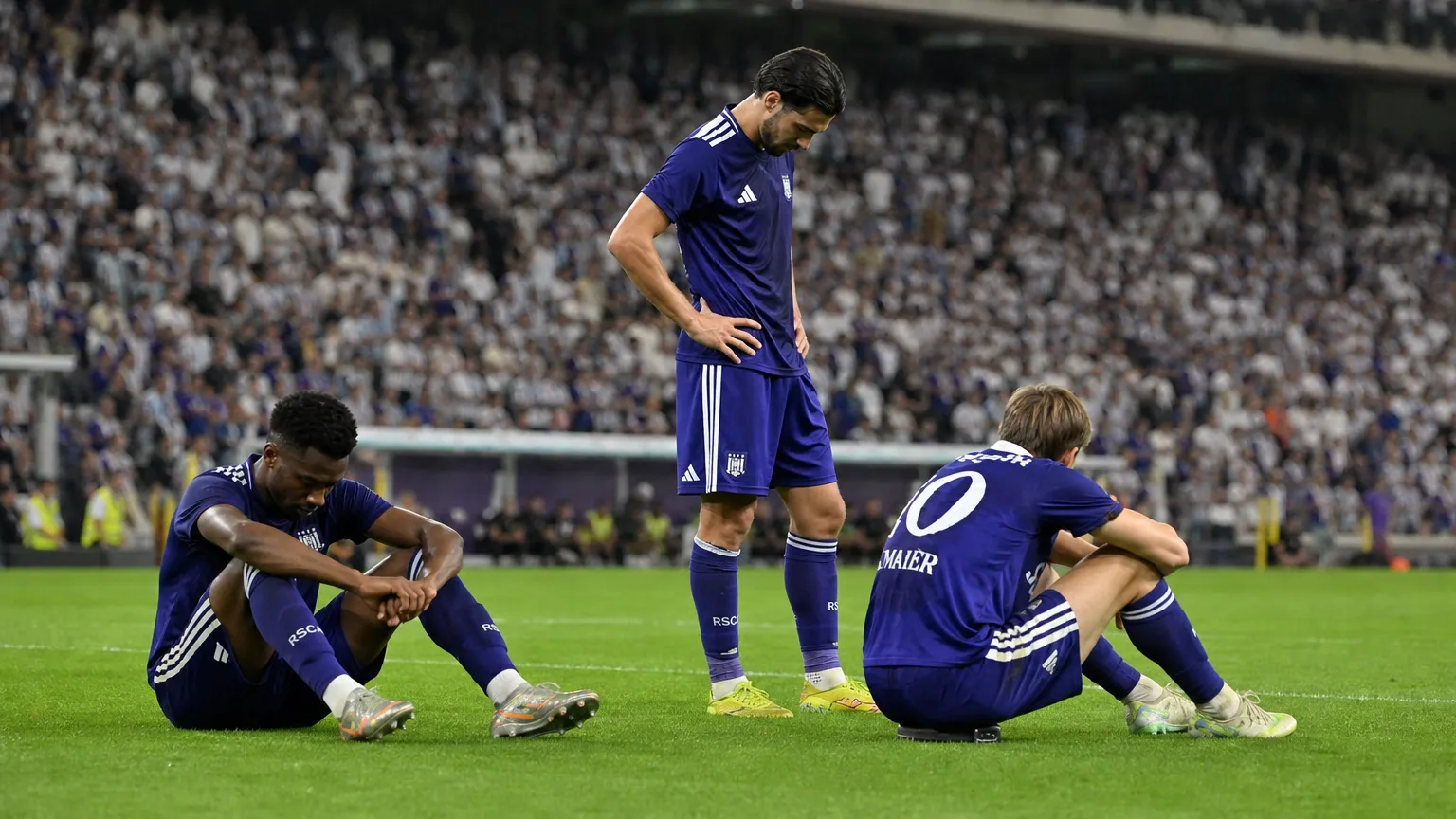 Teleurgestelde Anderlecht-spelers in paarse wedstrijdtenues na het laatste fluitsignaal.