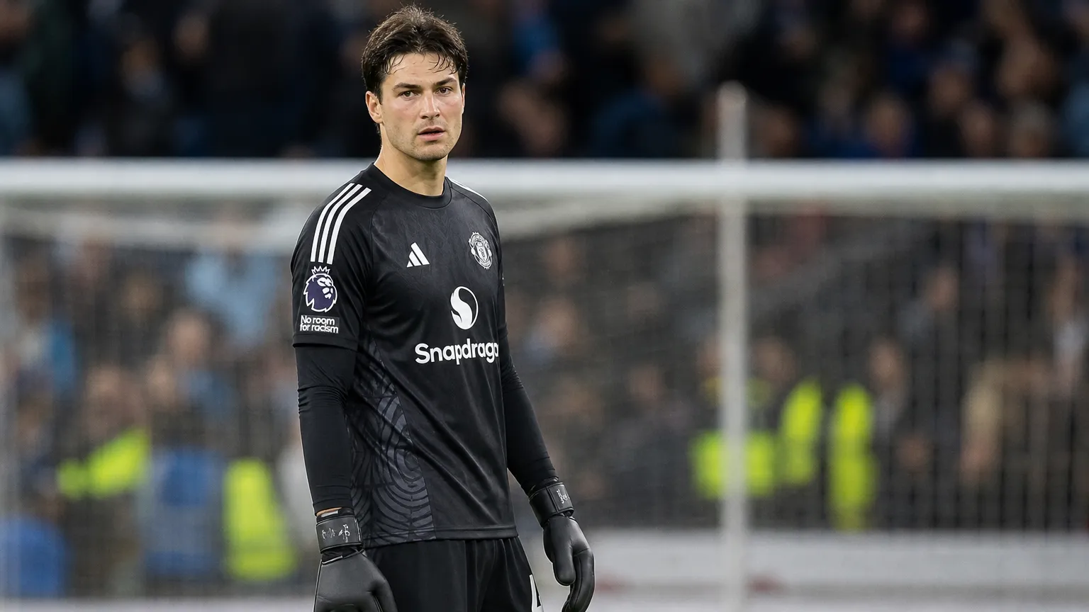 Senne Lammens in doelmansoutfit van Manchester United in het strafschopgebied na een wedstrijd.