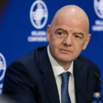 Gianni Infantino spreekt met journalisten in een stadionmediaruimte.