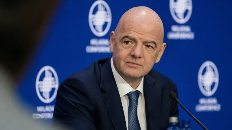 Gianni Infantino spreekt met journalisten in een stadionmediaruimte.