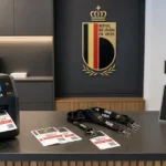 Operationele media-accreditatiebalie met een KBVB-embleem op een wandpaneel.