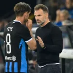 Een speler van Club Brugge overlegt langs de zijlijn met een staflid.