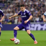 Anderlecht-spelers in paarse tenues tijdens een voetbalactie op het veld.