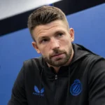Brandon Mechele spreekt tijdens een persmoment van Club Brugge in een zwarte clubjas.