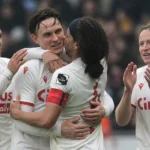 Een groep Standard-spelers viert samen op het veld na de wedstrijd.