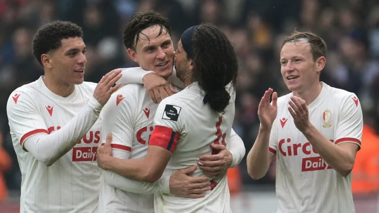 Een groep Standard-spelers viert samen op het veld na de wedstrijd.