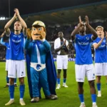 Een groep KRC Genk-spelers applaudisseert op het veld richting de tribunes.