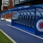 Lege technische zone in het stadion van Rangers FC met een clubembleem op de dug-out.