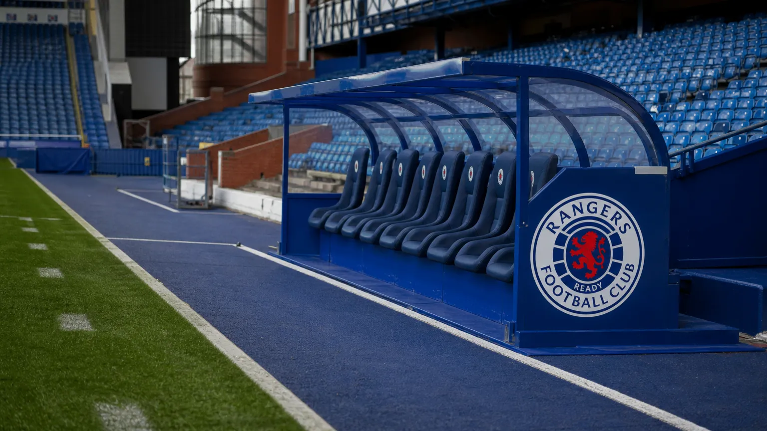 Lege technische zone in het stadion van Rangers FC met een clubembleem op de dug-out.