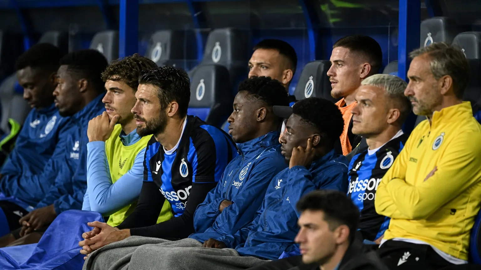 Een groep spelers van Club Brugge op de bank tijdens een wedstrijd.