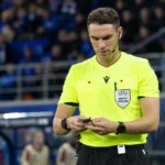 Sandro Schärer wandelt als UEFA-scheidsrechter over het veld voor een Europese wedstrijd.
