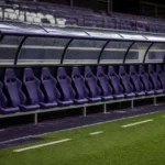 Lege dug-out van Anderlecht na de wedstrijd met een clubembleem op het zijpaneel.